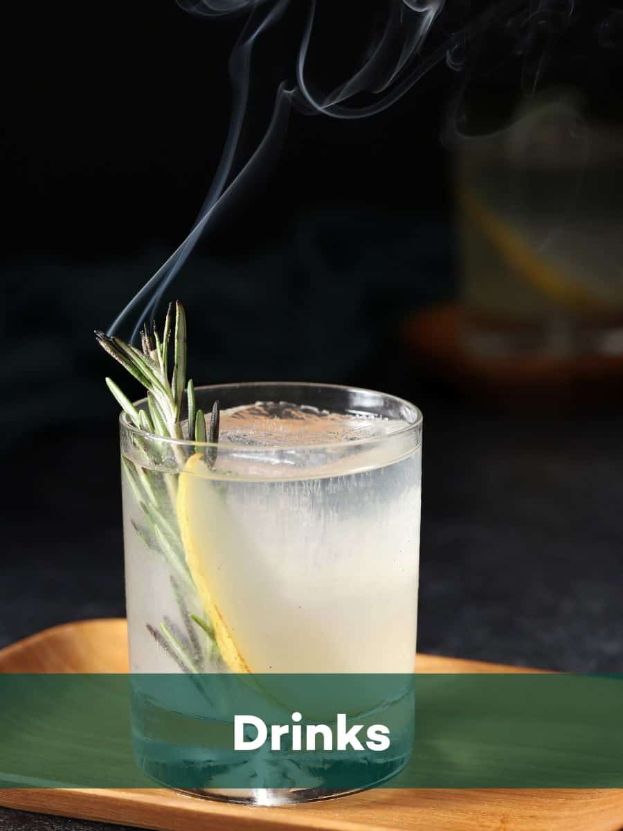 Drinks - Smoke curling off rosemary in a rocks glass.