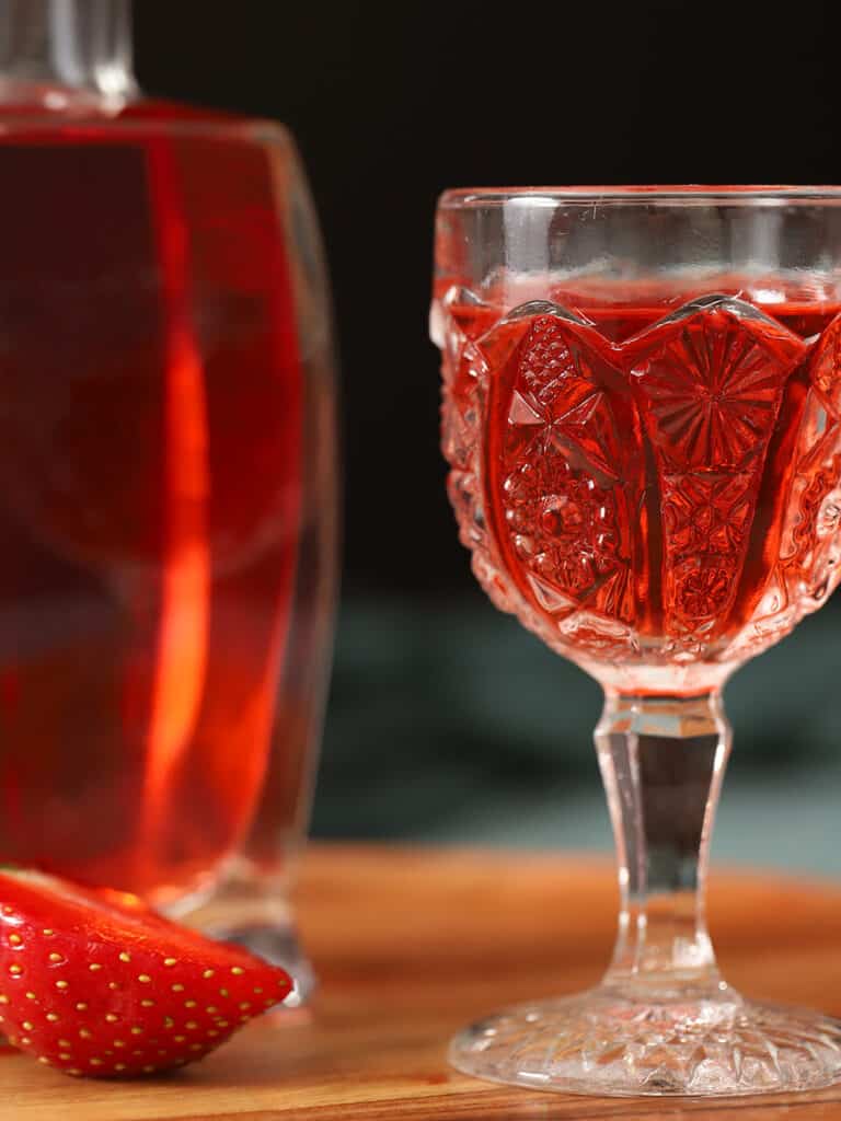 Close up of red liquid in a decorative glass.