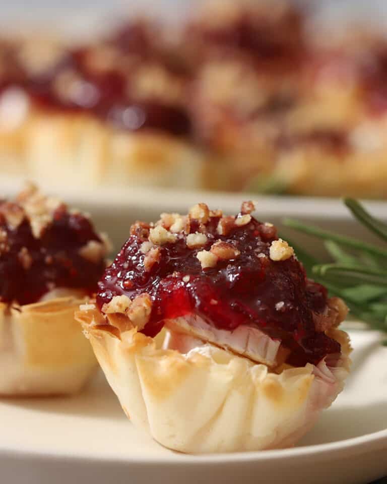 A small phyllo cup filled with cheese and cranberry sauce.